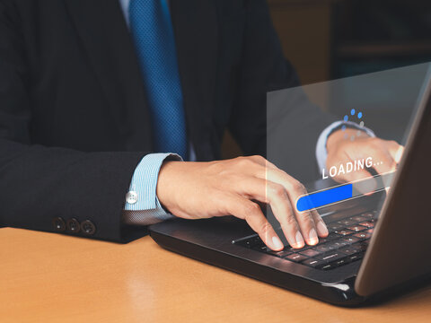 Businessman uses a laptop for loading and processing data on a virtual screen