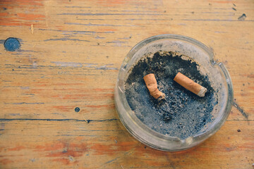 ashtray with old cigarettes on a rustic table