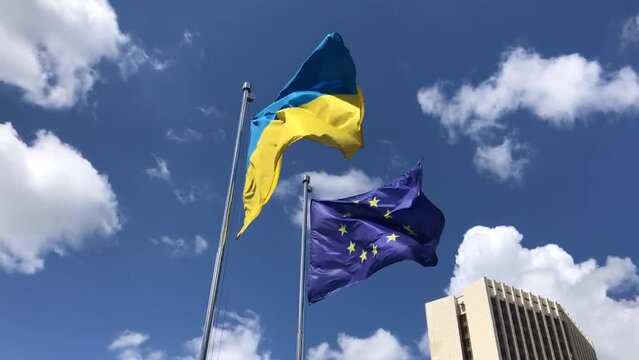 flags of ukraine and european union flutter in the wind