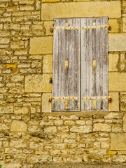 Stone building with shutters window, France
