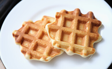 Fresh delicious homemade waffles on white plate