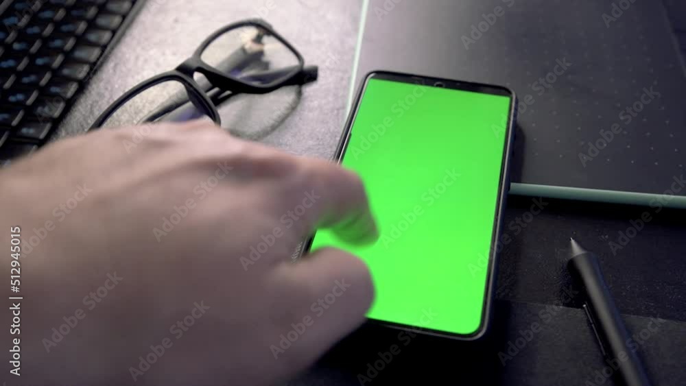 Aufkleber Man unlocking and using mobile phone at his working place. 4k video footage with green screen smartphone
