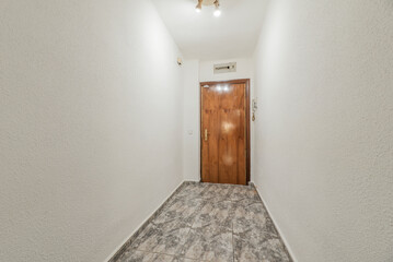Entrance door to a home with ceramic stoneware floors and walls painted in gotelet white