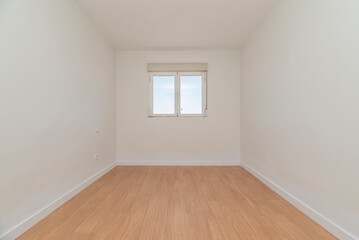 Empty room with light oak flooring, white carpentry and aluminum window with views