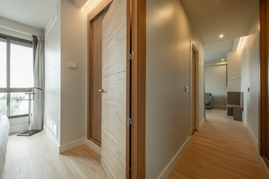 Living room corridor with light oak flooring, matching door carpentry and large windows with views