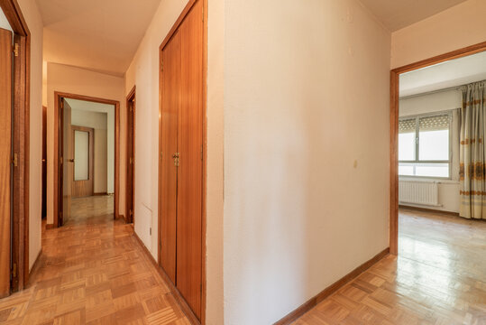 Distributor corridor with oak parquet flooring, wooden doors and access to several rooms