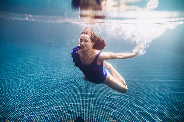 young beautiful woman swimming underwater.