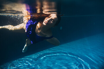 young beautiful woman swimming underwater.