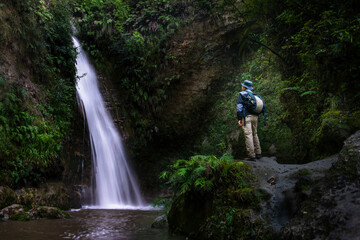 Tourist admiring Te Ana waterfalls, Hawke’s Bay. - obrazy, fototapety, plakaty
