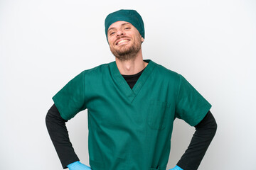 Surgeon Brazilian man in green uniform isolated on white background posing with arms at hip and smiling