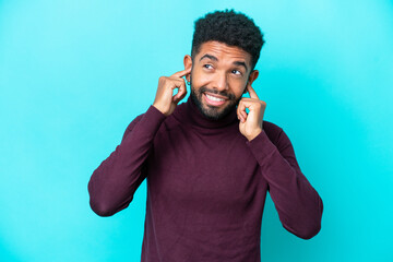 Young Brazilian man isolated on blue background frustrated and covering ears