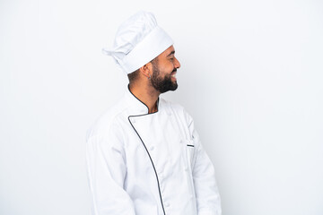 Young Brazilian chef man isolated on white background laughing in lateral position