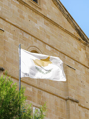 Vertical shot of a Cypriot Flag flying in Nicosia, Cyprus with a church in the back bround