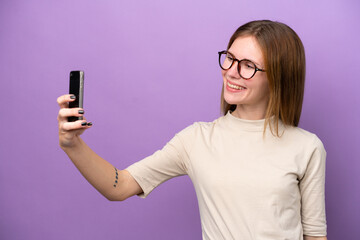 Young English woman isolated on purple background making a selfie