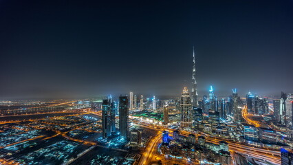 Fototapeta na wymiar Aerial panorama of tallest towers in Dubai Downtown skyline and highway night timelapse.