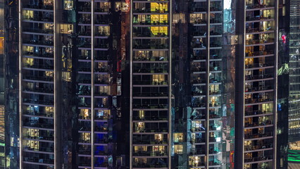 Fototapeta na wymiar Windows in apartments of a high class building at night timelapse