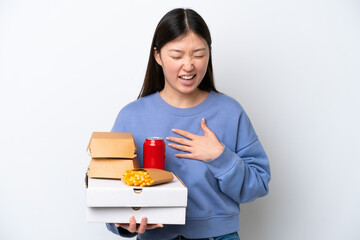 Young Chinese woman holding fast food isolated on white background smiling a lot