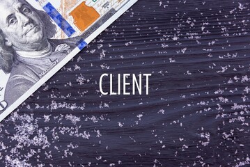 CLIENT - word (text) on a dark wooden background, money, dollars and snow. Business concept (copy space).
