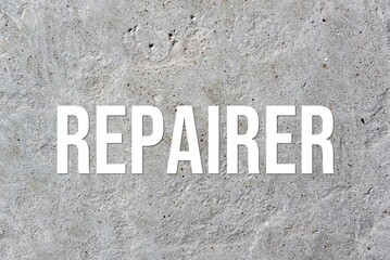 REPAIRER - word on concrete background. Cement floor, wall.