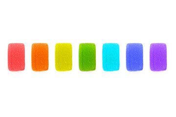 Rainbow colored jelly candies arranged on white