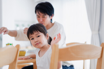 Fototapeta premium パパと一緒にご飯を食べる小さな女の子