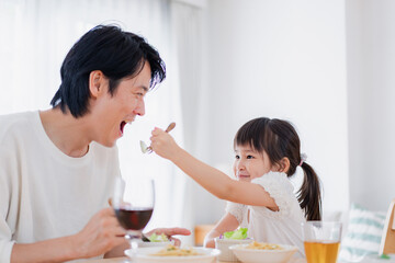 パパと一緒にご飯を食べる小さな女の子