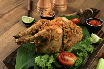 Tuinposter Ayam Betutu. Balinese Roast Chicken Stuffed with Cassava Leaves. © Ika Rahma