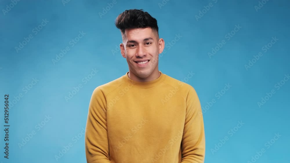 Poster young man smiling at the camera while standing over an isolated background.