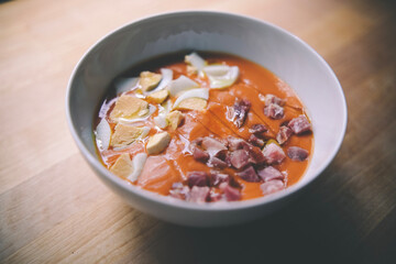 Plato de salmorejo con huevo cocido y tacos de jamón.