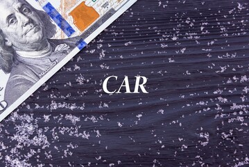 Fototapeta na wymiar CAR - word (text) on a dark wooden background, money, dollars and snow. Business concept (copy space).