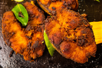 Fish fry on a frying pan with curry leaves. Close-up shot of Indian traditional Kerala style spicy...