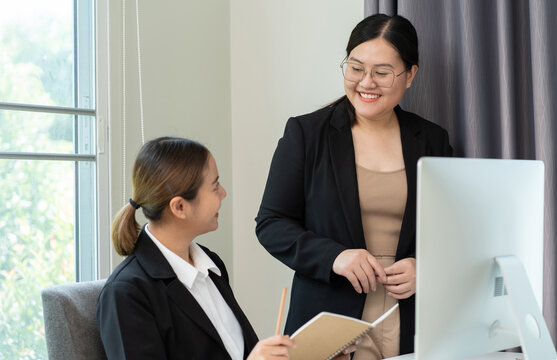 Two asian businesswomen working with computer