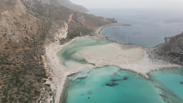 Aerial drone view of Balos beach, covered with fine white sand and located between the two creeks of the Tigani cape (Greece). Beautiful Mediterranean sea with turquoise waters.