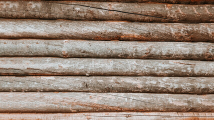 Background image of the wall surface made of brown wooden logs, logs close-up, a warm house made of...