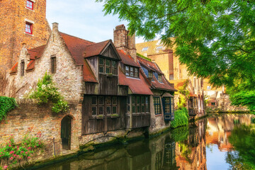 Fototapeta na wymiar Bruges, Belgium - Cityscape overlooking old quiet streets with old brick houses and a canal on a summer sunny day.