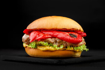 Chicken burger with sweet peppers on a black background