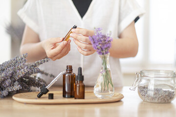 Using natural essential oil in a home spa ritual. A woman takes care of her skin and hair.