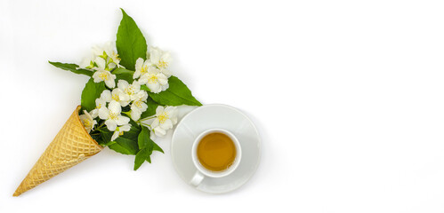 jasmine tea in a white cup, a medicinal herbal drink for dietary nutrition, a healthy lifestyle, twigs of flowering jasmine in a cone on a white background, top view