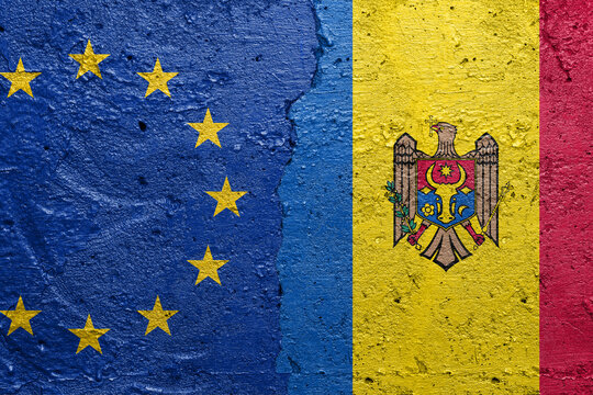 European Union and Moldova - Cracked concrete wall painted with a EU flag on the left and a Moldovan flag on the right stock photo