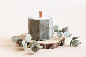 Handmade candles from paraffin and soy wax in concrete plaster candlestick with wooden wick and dry...