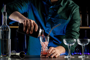 Bartender's hands serving cocktails on bar counter in a restaurant, pub. Mixed drinks. Alcoholic cooler beverage at nightclub on dark background