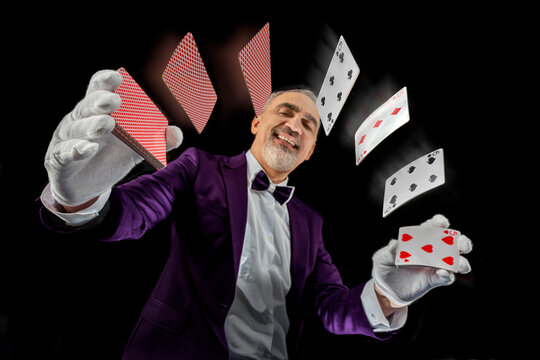 Magician with cards, Card manipulation, Croupier or casino dealer at gambling club or casino. Close up of male hand with poker cards
