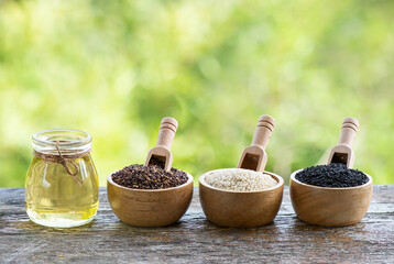 Red ,white ,black sesame seeds and oil on nature background.