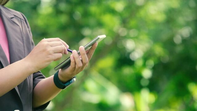 Young businesswoman making wite someting on smartphone