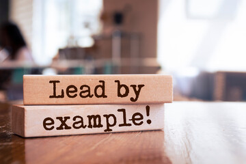 Wooden blocks with words 'Lead by example'.