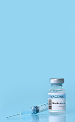 Vaccine in a bottle with a syringe on a blue background.The concept of medicine, healthcare and science.Coronavirus vaccine.Copy space for text.Banner