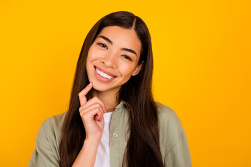 Photo of gorgeous positive person finger touch chin toothy beaming smile isolated on yellow color background