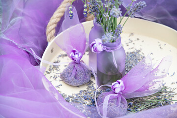 Lilac lavender in vases and lavender sachets,chiffon bags on a tray,still life