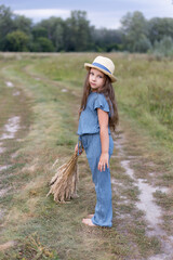 Kid girl 4-5 year old wearing  hat  outdoors. Looking at camera.