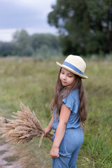  Cute girl in a hat in a field. Kid girl 4-5 year old wearing  hat  outdoors.